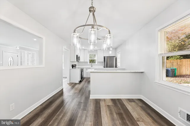 a view of kitchen and hall with wooden floor