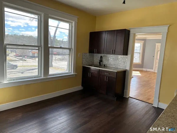 a kitchen with a sink wooden cabinets and a wooden floor