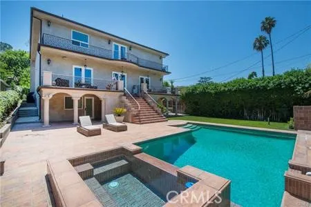 a view of a house with pool fire pit a patio and a garden