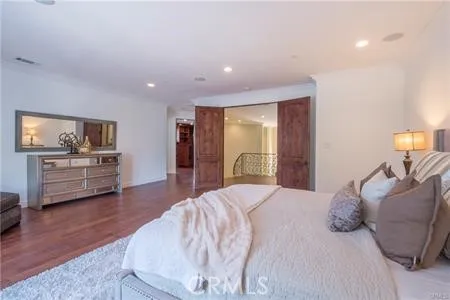 a large bedroom with a bed and a view of kitchen