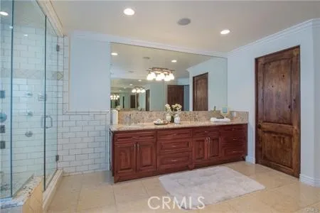 a bathroom with a granite countertop sink a mirror and a shower