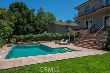 a house view with swimming pool and garden space