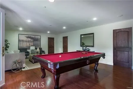 a living room with a table tennis table and wooden floor