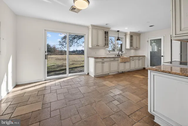 a large white kitchen with cabinets and a wooden floor