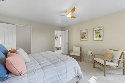 a bedroom with a bed a couch and painting on the wall