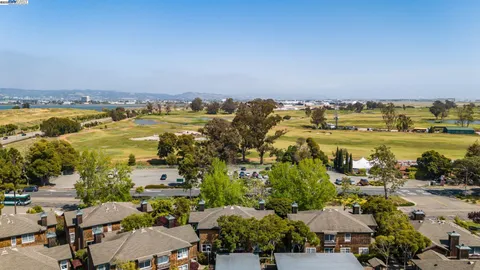 an aerial view of ocean and residential houses with outdoor space