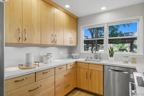 a kitchen with stainless steel appliances granite countertop a sink a stove and cabinets