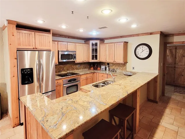 a kitchen with stainless steel appliances granite countertop a stove refrigerator sink and dishwasher