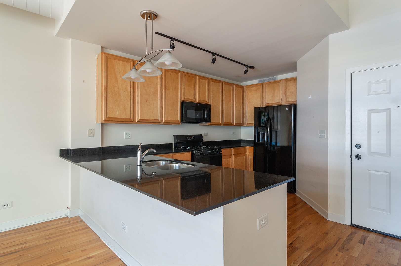 845 West Monroe Street, Unit 2F Chicago, IL 60607 - Photo 5 of 10 a kitchen with granite countertop a refrigerator a sink and wooden cabinets