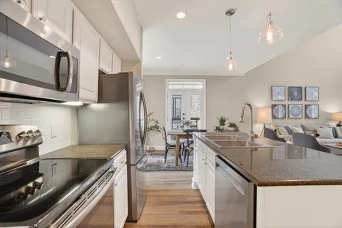 a kitchen with stainless steel appliances granite countertop a sink a stove and a refrigerator