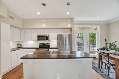 a kitchen with stainless steel appliances granite countertop a refrigerator and a stove top oven
