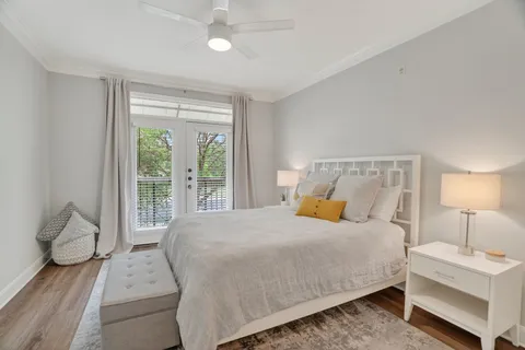 a bedroom with a large bed and a lamp on dresser