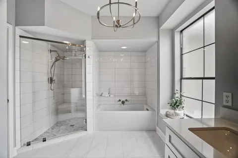 a bathroom with a tub sink and mirror