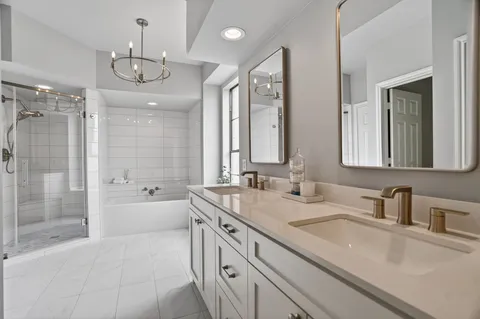 a spacious bathroom with a sink a large mirror and a bathtub