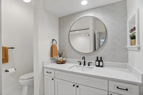 a bathroom with a toilet a sink and mirror