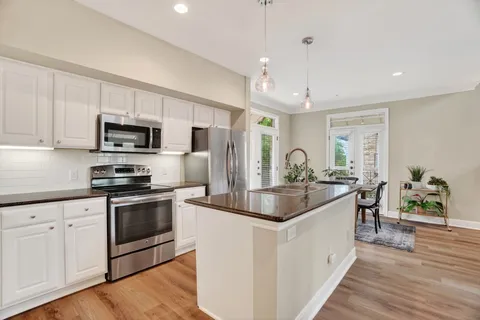 a kitchen with sink a microwave and cabinets