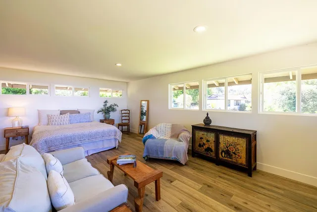 a kitchen with stainless steel appliances a refrigerator a stove a dining table and chairs with wooden floor