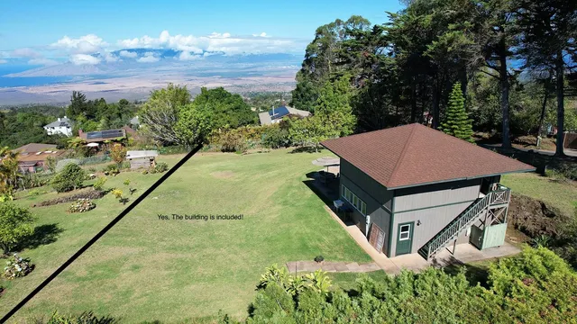 a aerial view of a house with table chairs and a yard