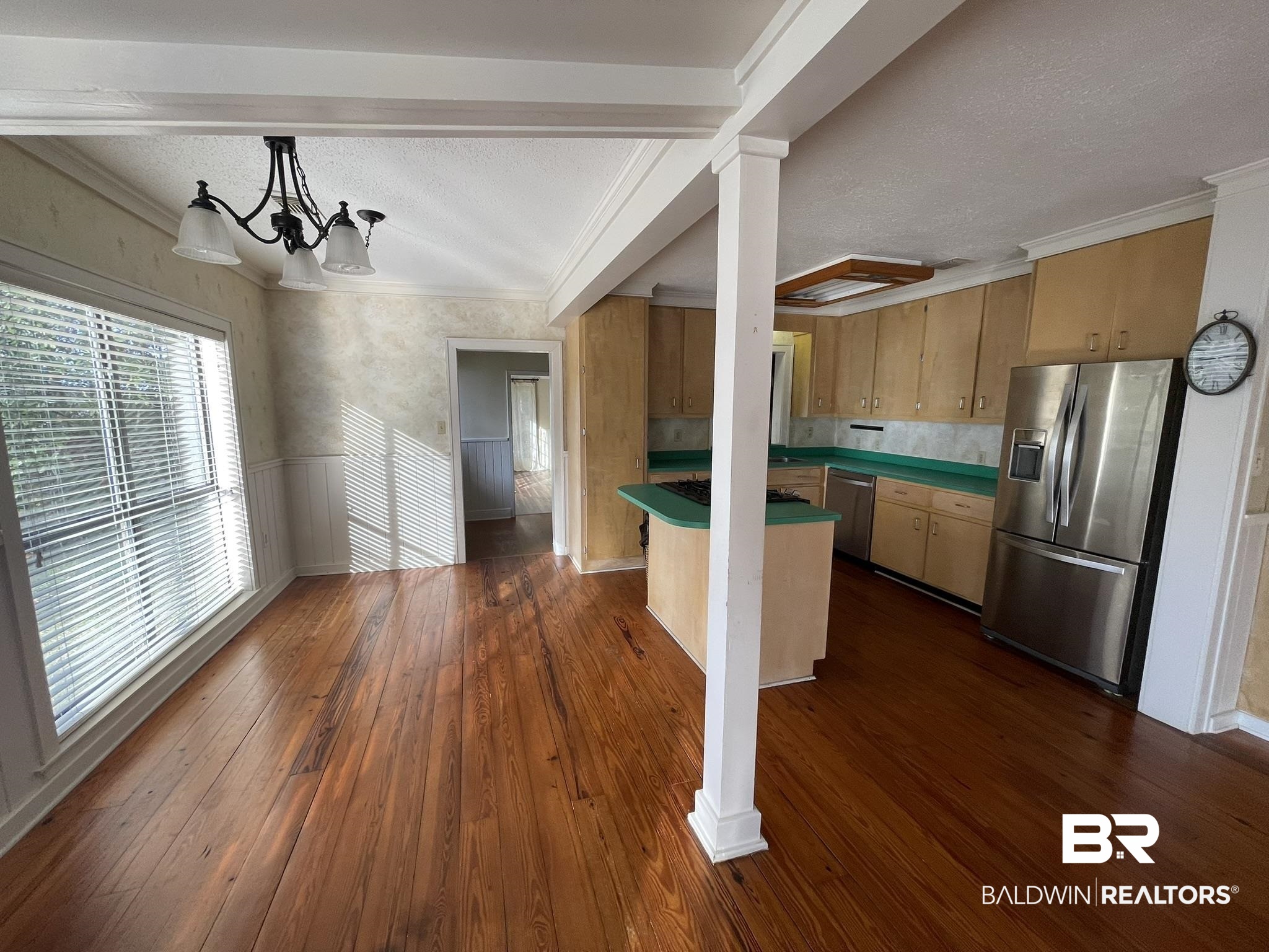 6621 Purvis Road Daphne, AL 36527 - Photo 16 of 59 Kitchen featuring stainless steel appliances, a wainscoted wall, dark wood-type flooring, a textured ceiling, and ornamental molding