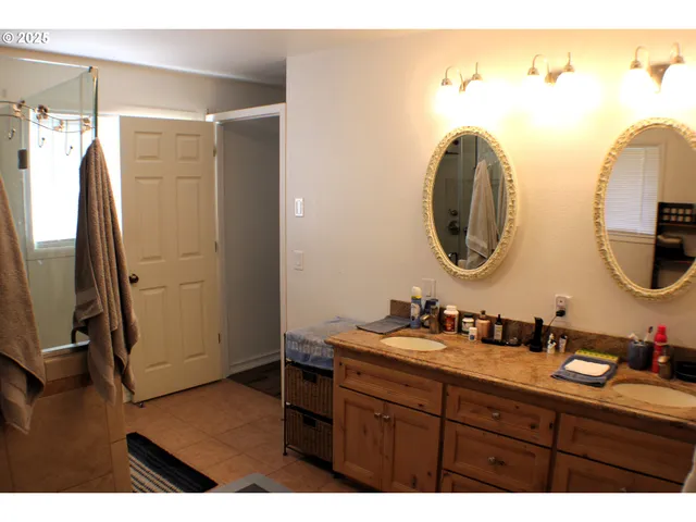 a bathroom with a sink mirror and a shower