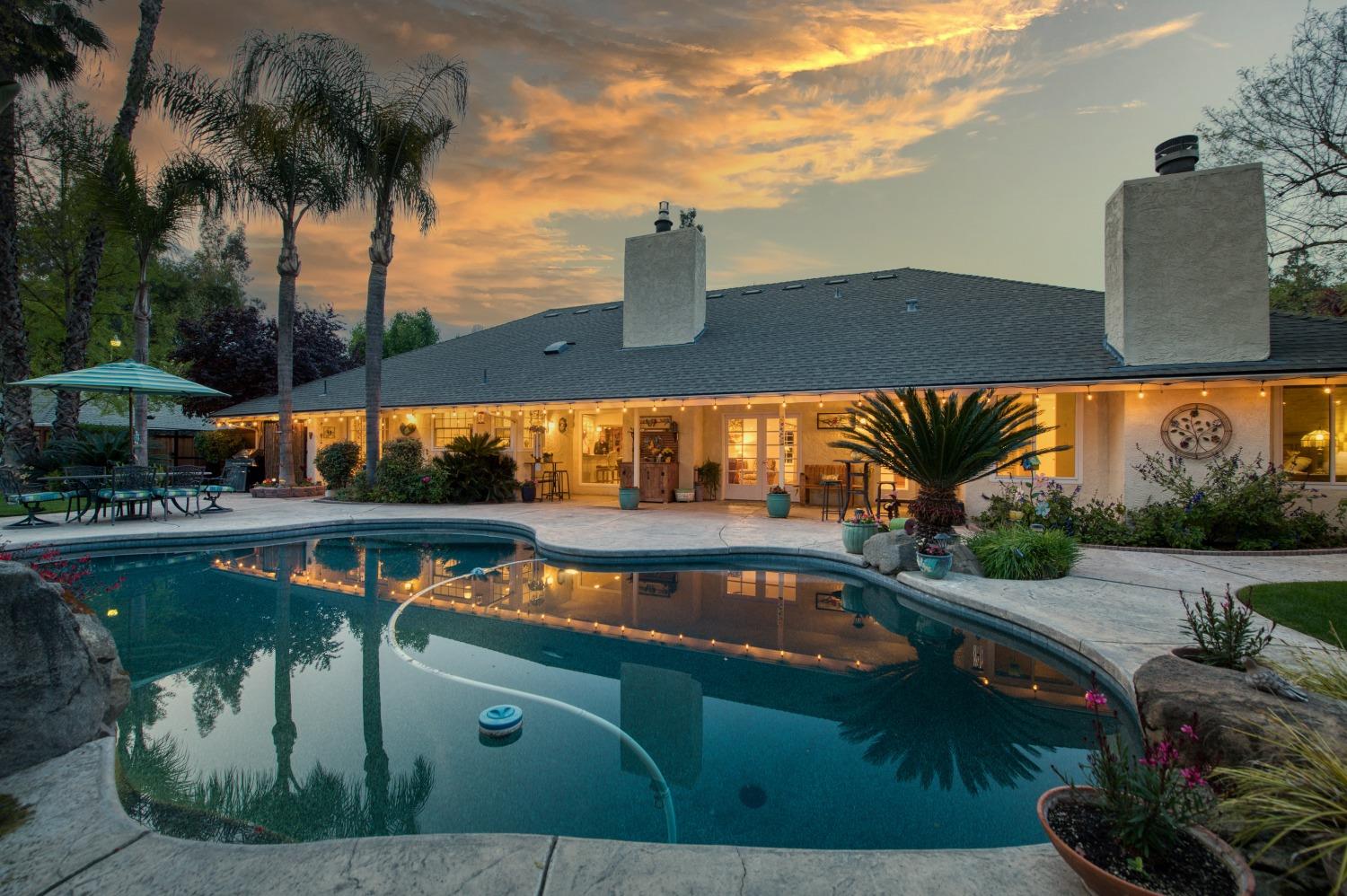 an outdoor view of swimming pool with seating space