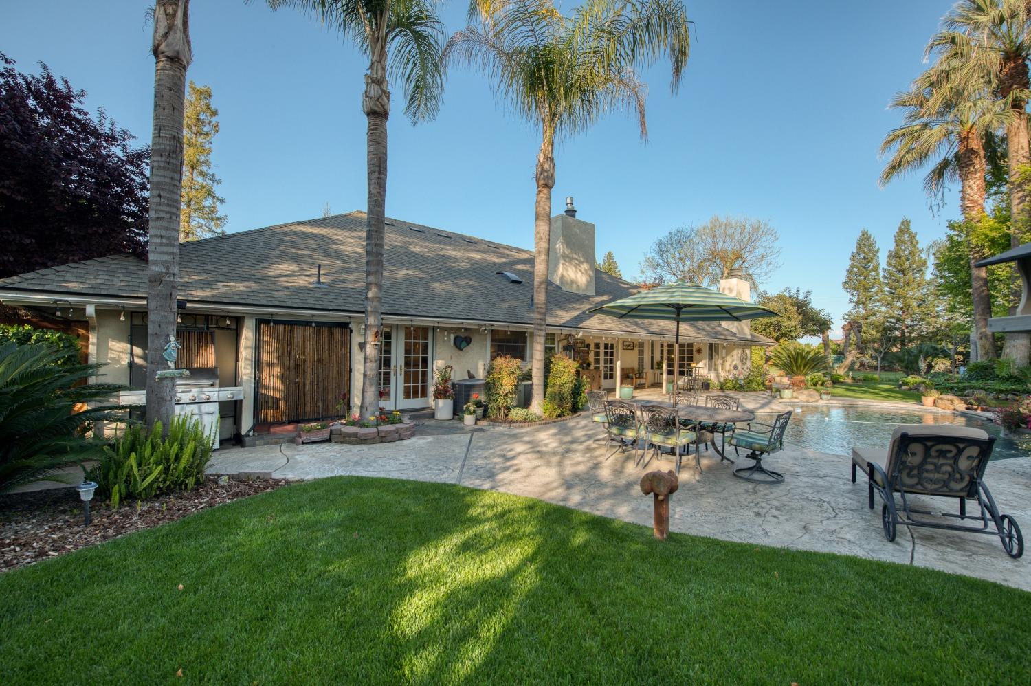 2988 Enterprise Avenue Clovis, CA 93619 - Photo 35 of 99 a view of a patio with table and chairs potted plants and palm tree