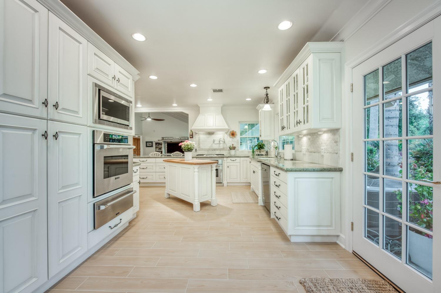 2988 Enterprise Avenue Clovis, CA 93619 - Photo 65 of 99 a kitchen with kitchen island granite countertop lots of white stainless steel appliances cabinets and a sink
