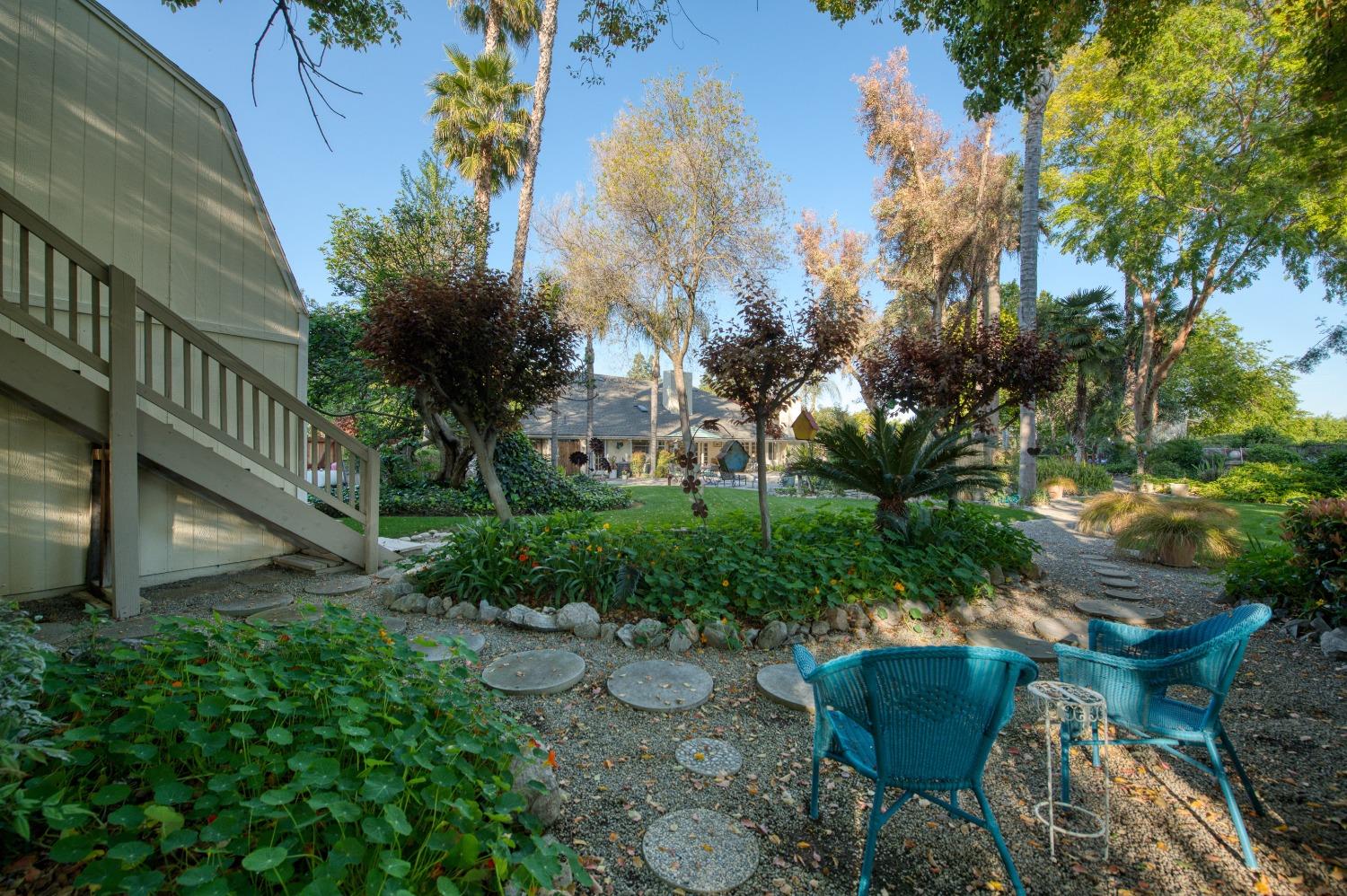 2988 Enterprise Avenue Clovis, CA 93619 - Photo 90 of 99 a backyard of a house with table and chairs plants and large trees
