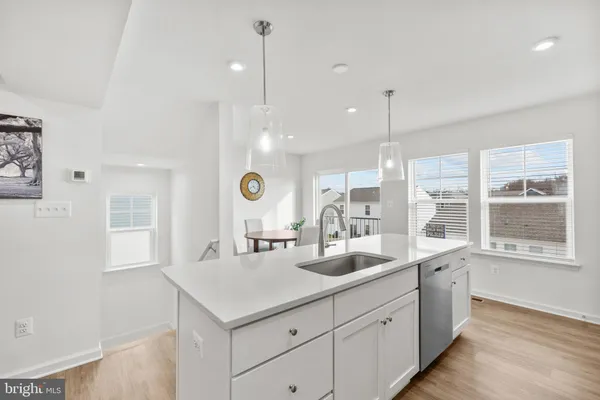 a kitchen with sink a mirror and wooden floor