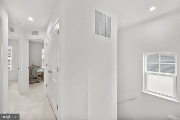 a view of a hallway with a livingroom and a bathroom