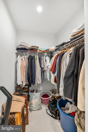 a view of walk in closet with clothes and shoes
