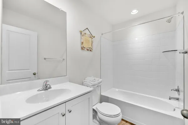 a bathroom with a bathtub shower sink vanity and toilet