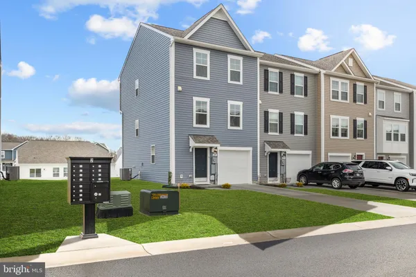 a front view of a house with a yard and trees