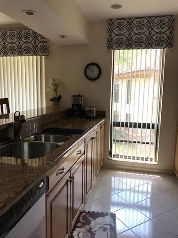 a kitchen with granite countertop a sink and a window