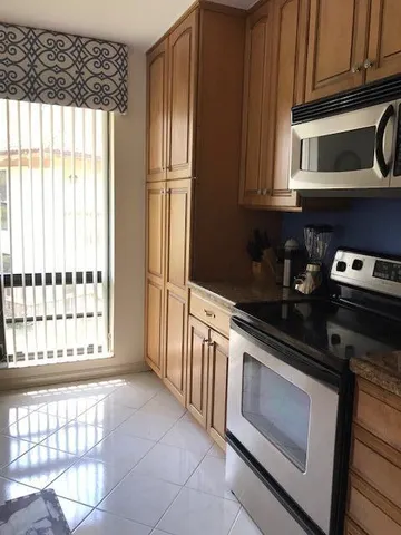 a kitchen with stainless steel appliances wooden cabinets and a stove top oven