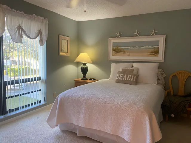 a bedroom with a bed and lamp next to a window