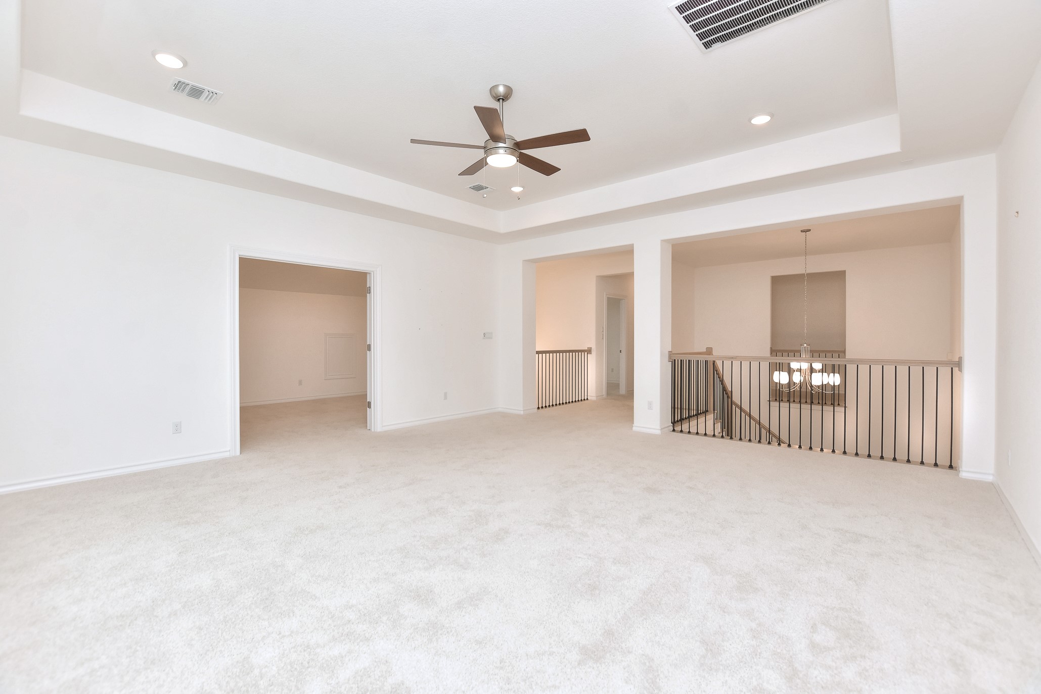 309 Wolf Rdg Road Georgetown, TX 78628 - Photo 24 of 39 Carpeted empty room featuring a raised ceiling, a ceiling fan, and hanging lights