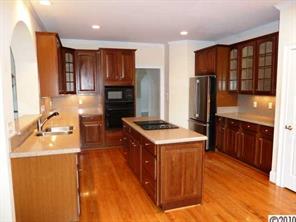 908 Ashford Way Fort Mill, SC 29708 - Photo 6 of 16 a kitchen with stainless steel appliances granite countertop a stove a refrigerator and a sink with wooden cabinets
