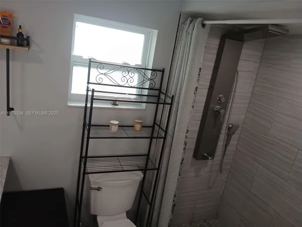 a bathroom with a glass door shower and toilet