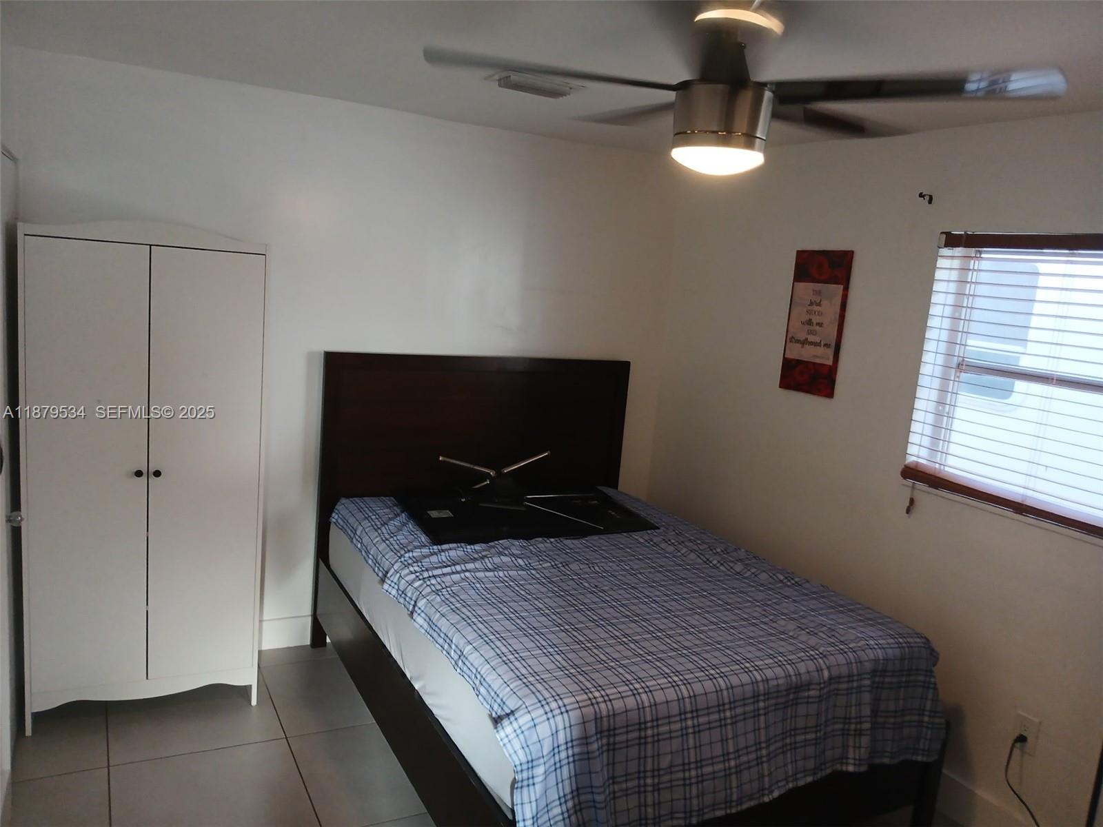 11510 Southwest 182nd Terrace, Unit 2 Miami, FL 33157 - Photo 6 of 7 a bedroom with a bed and a window