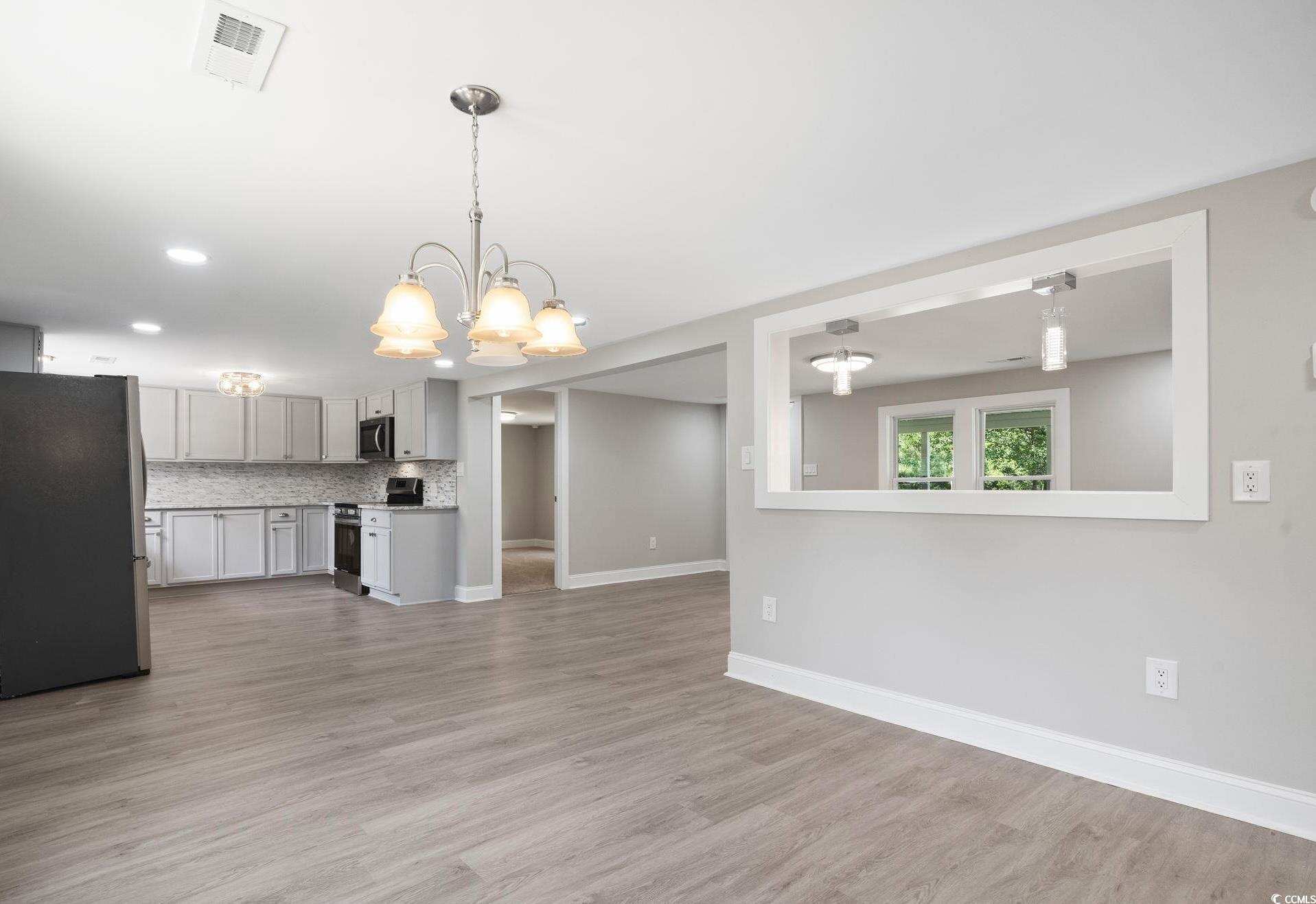 2074 Jem Lane Conway, SC 29527 - Photo 6 of 15 Unfurnished living room with light wood-style flooring and a chandelier