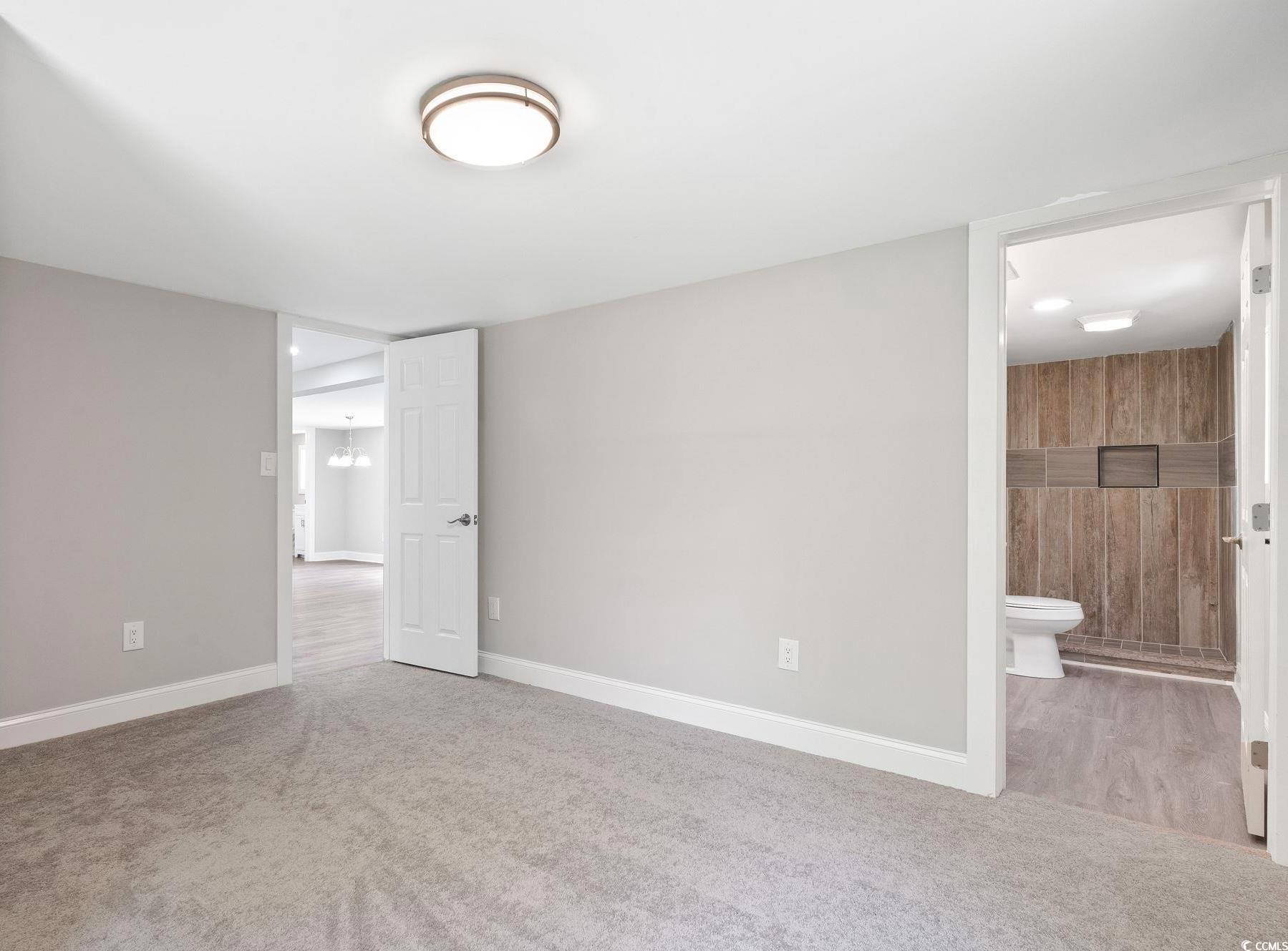 2074 Jem Lane Conway, SC 29527 - Photo 10 of 15 Unfurnished bedroom featuring light colored carpet, ensuite bathroom, and a chandelier