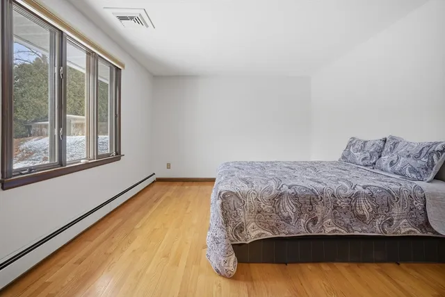 a bed sitting in a bedroom next to a window