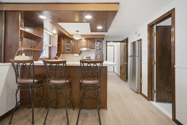 a dining room with stainless steel appliances kitchen island granite countertop furniture and a refrigerator