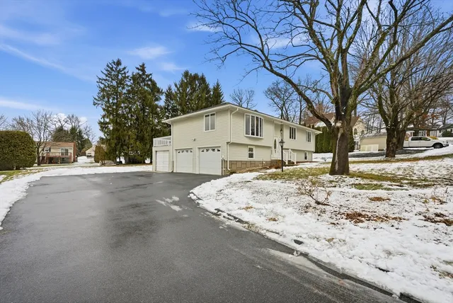 a view of a white house with a snow on the road