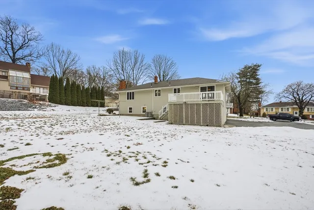 a front view of a house with a yard covered in snow