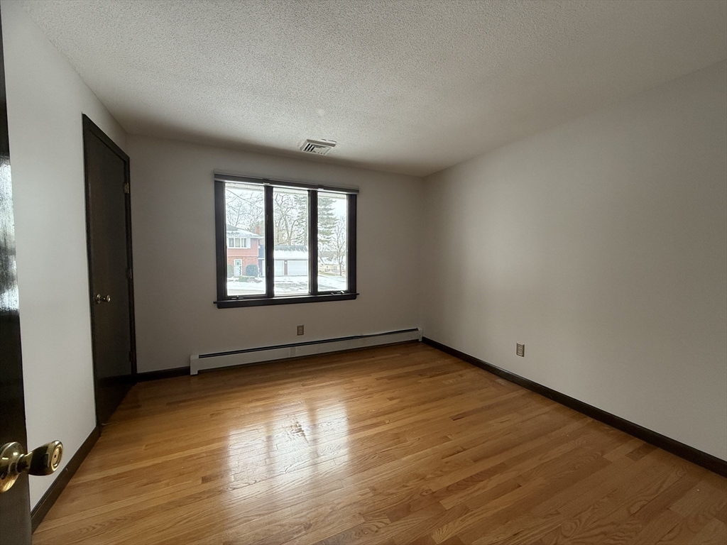 63 Helene Street Ludlow, MA 01056 - Photo 7 of 11 an empty room with wooden floor and windows