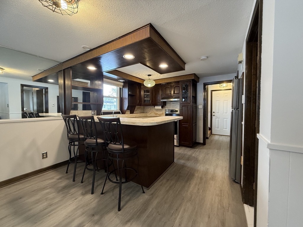 63 Helene Street Ludlow, MA 01056 - Photo 9 of 11 a kitchen with stainless steel appliances kitchen island granite countertop a table chairs sink and cabinets