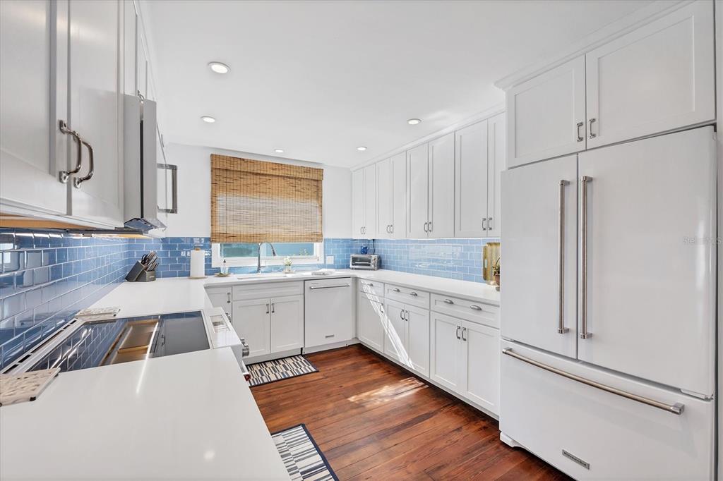 380 Tarpon Avenue Boca Grande, FL 33921 - Photo 11 of 38 a large white kitchen with stainless steel appliances and white cabinets