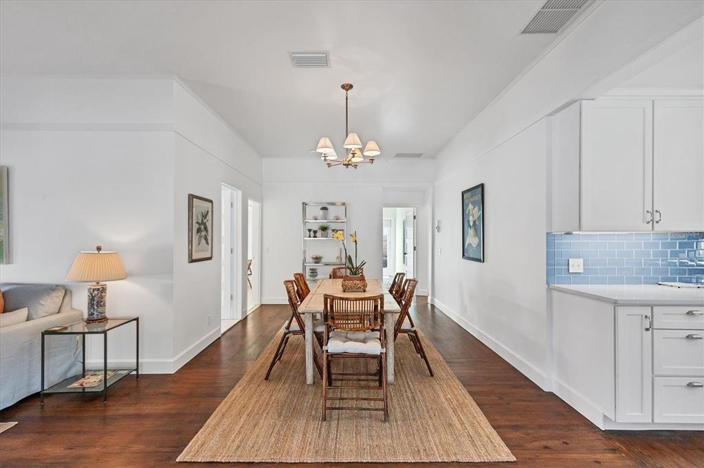 380 Tarpon Avenue Boca Grande, FL 33921 - Photo 14 of 38 a dining room with wooden floor a chandelier a wooden table and chairs